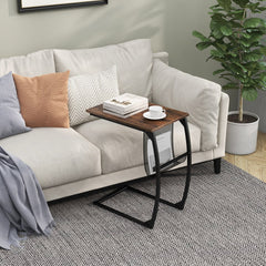C-shaped sofa side snack table next to a sofa with a book on top