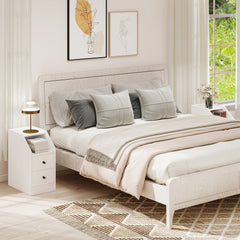 The white end table placed next to a bed in a bright and modern bedroom setting