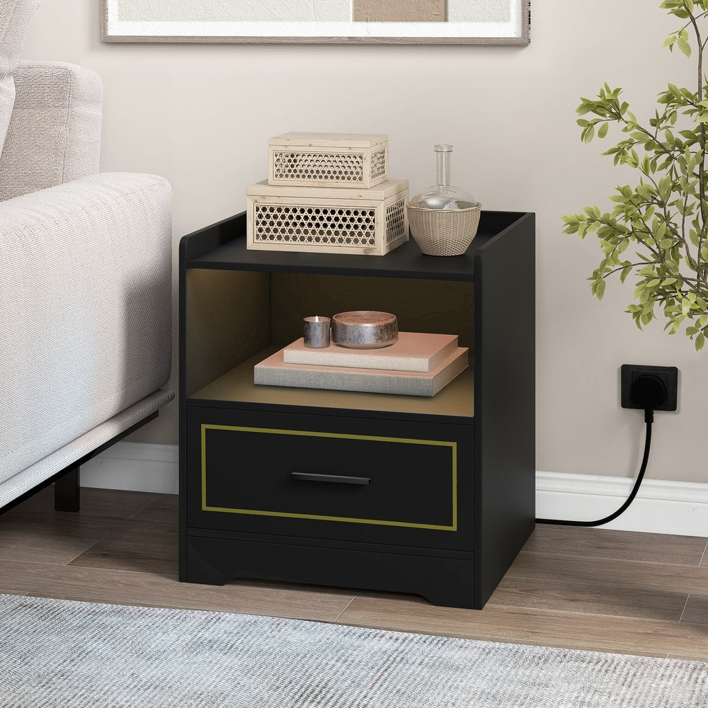 The black nightstand styled with decorative boxes and a candle in a living room