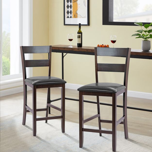 Two upholstered bar stools placed at a high table in a dining area