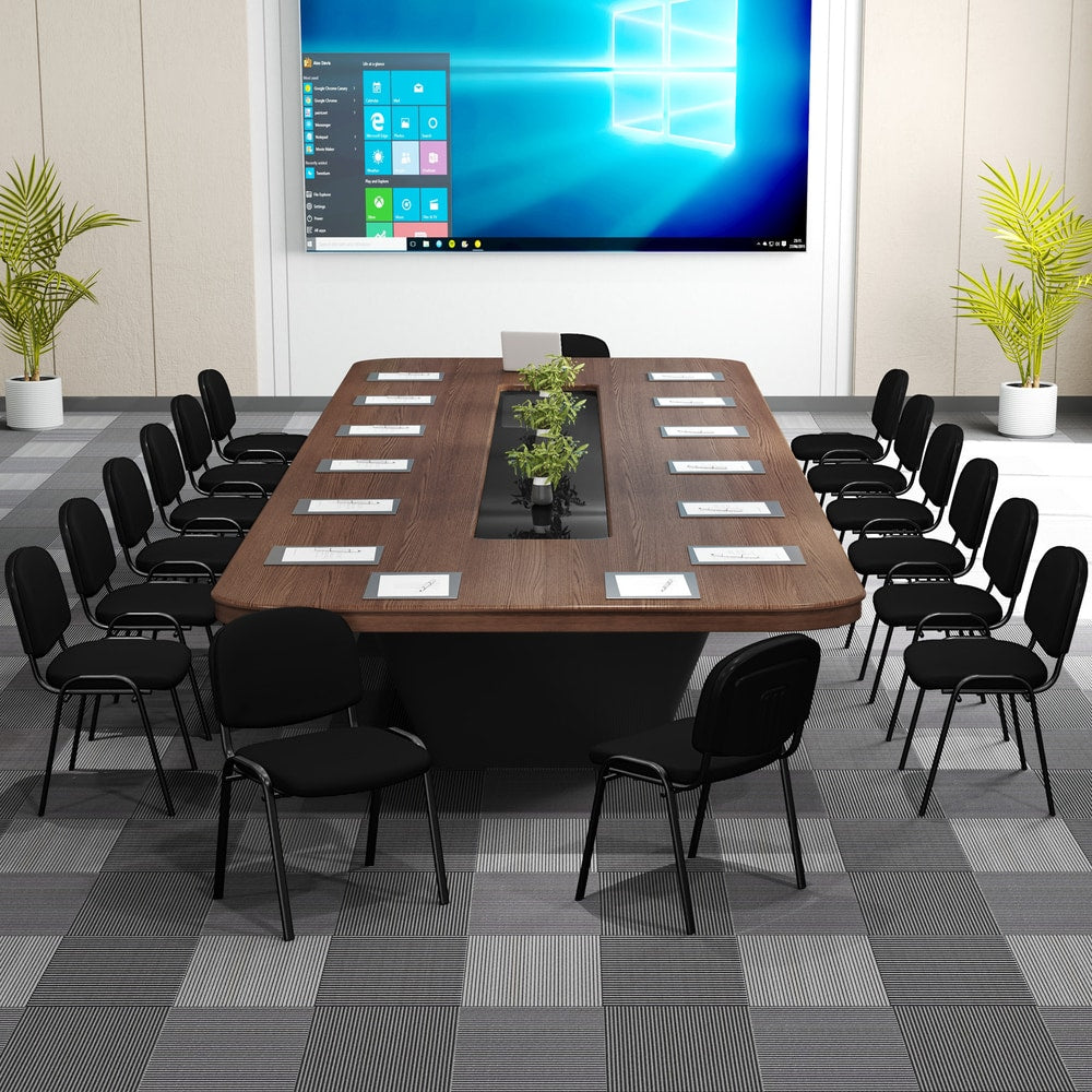 The office chairs arranged in rows around a long boardroom table with a large screen behind