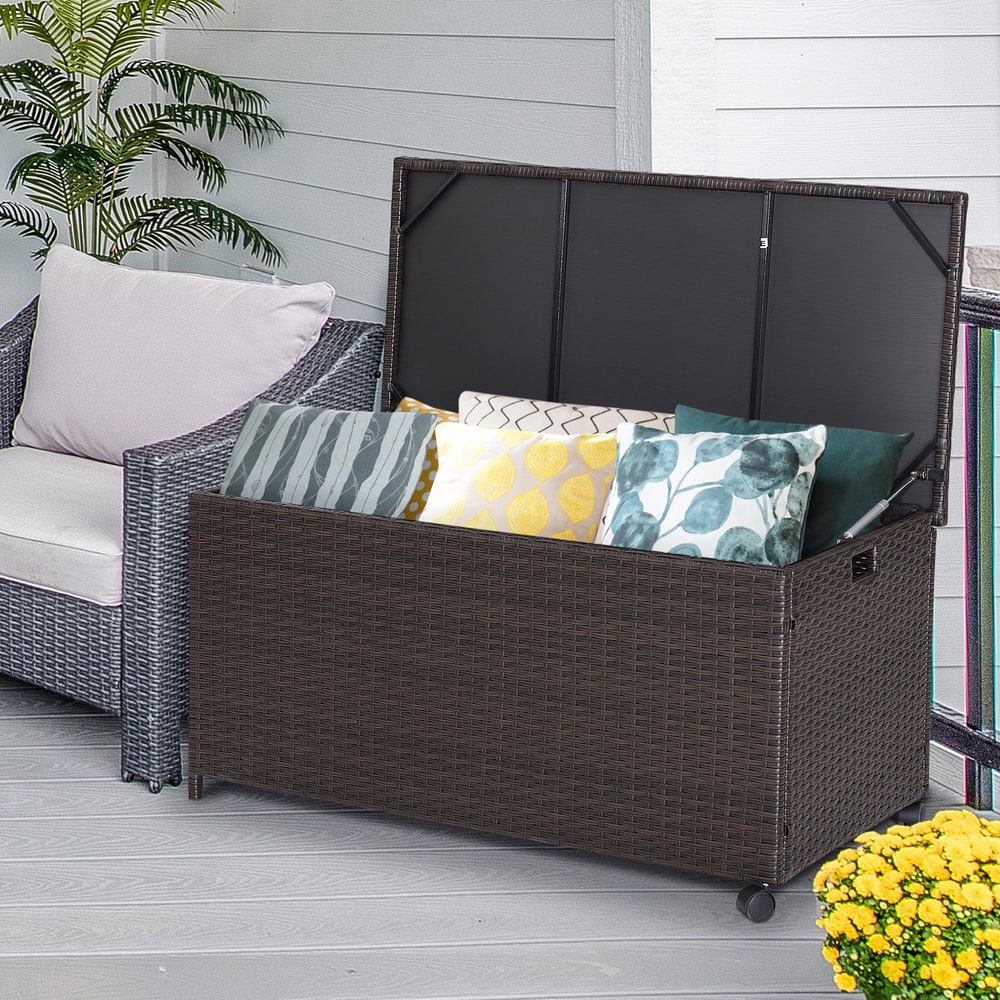 The patio rattan storage container shown on a deck with outdoor furniture and cushions inside