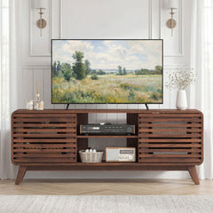 The entertainment center with a 65" TV and various decorative items on top