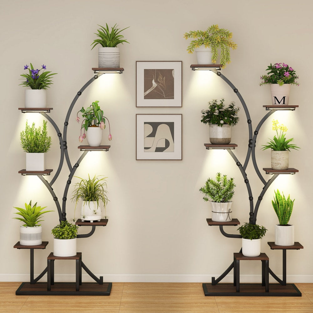 Two brown metal plant stands with plants on a wall background