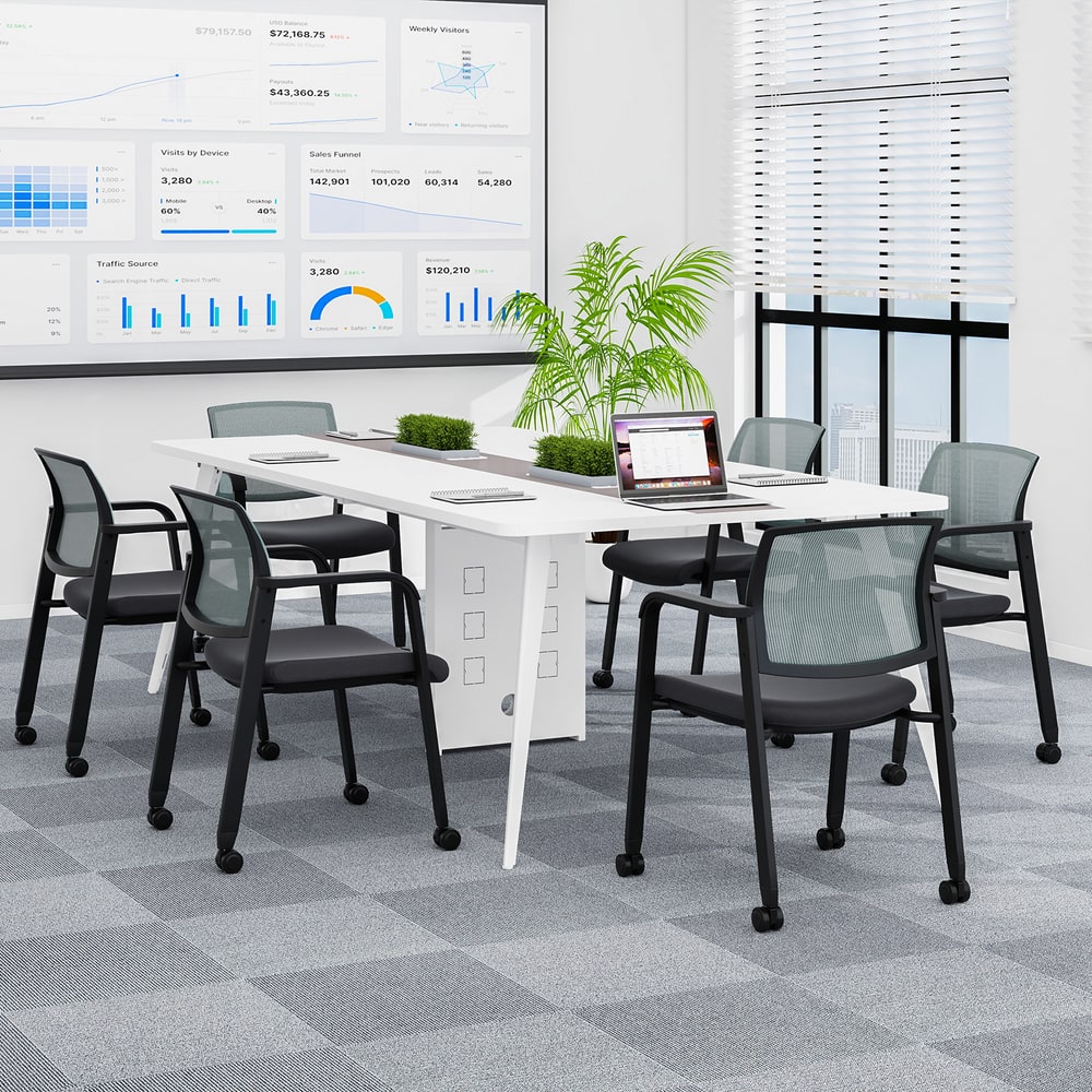 Four grey office chairs arranged around a meeting table in a modern office space