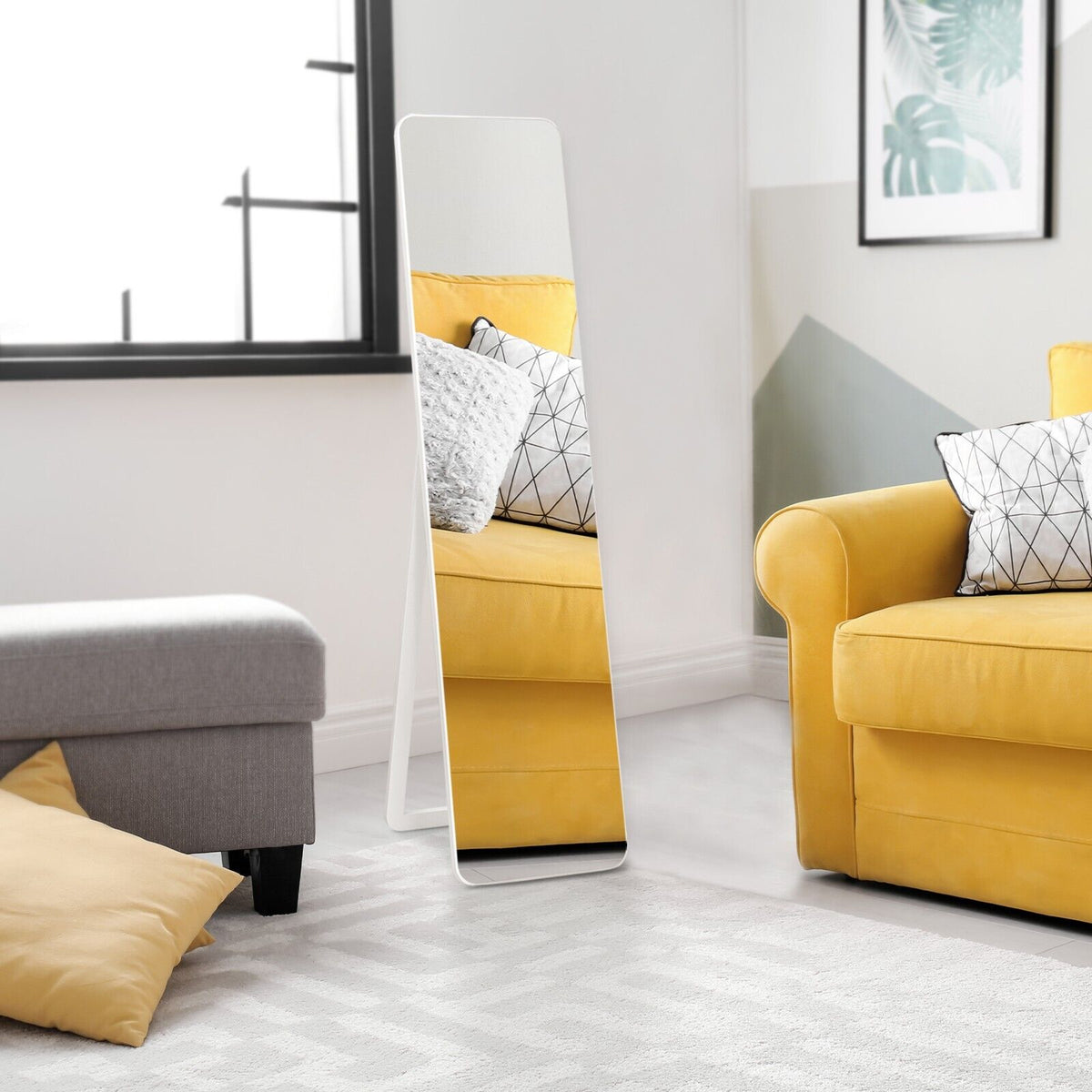 The full length mirror standing in a modern living room next to a yellow sofa