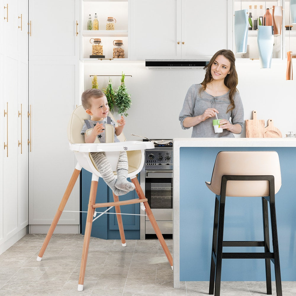 The high chair in a modern kitchen with a baby sitting inside and a woman standing nearby