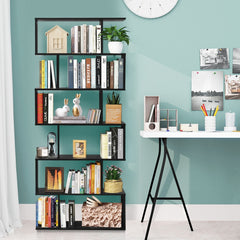 The black industrial bookcase standing in a home office next to a white desk