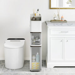 The slim white floor cabinet is shown next to a toilet in a modern bathroom setting
