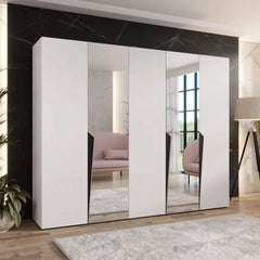 A white hinged wardrobe with mirrored doors in a minimalist room
