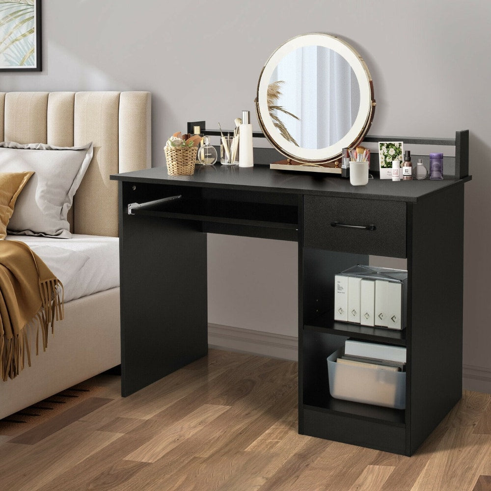 The black computer desk is shown in a bedroom setting with decorative items