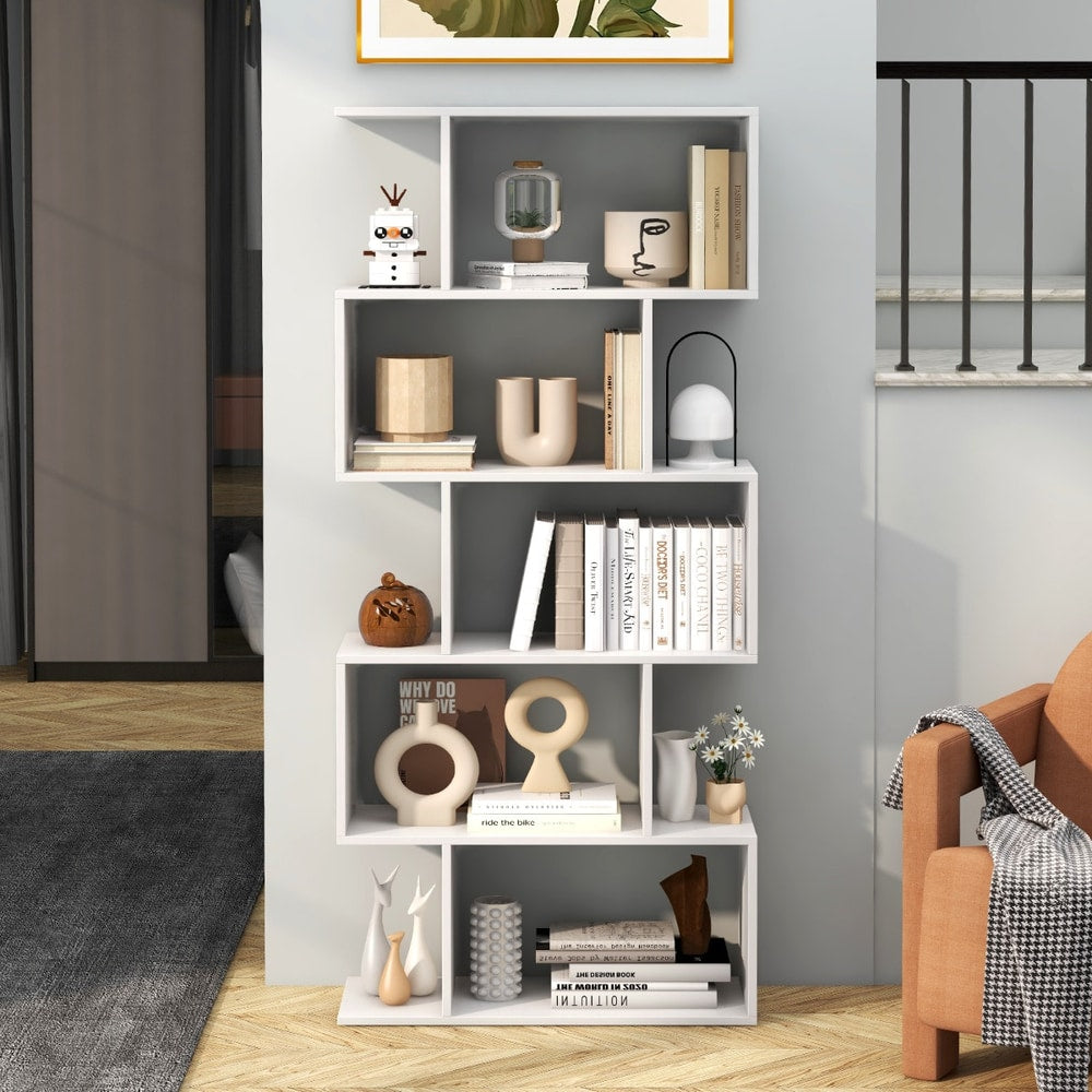 The white shelving unit in a living room, styled with books and decorative items