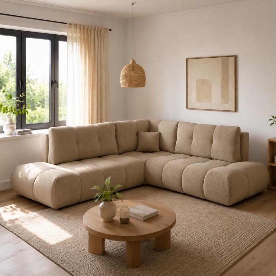 Corner Sofa Bed Soho II in a light beige fabric, shown in a living room setting with a round coffee table