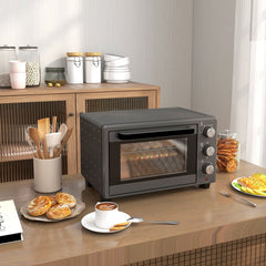 The countertop oven on a kitchen counter with pastries and coffee