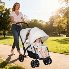 A beige double pushchair with two children sitting in it, being pushed along a path