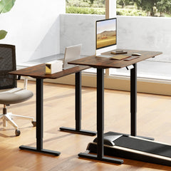 Two rustic brown electric standing desks, one with a treadmill underneath