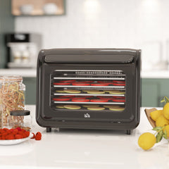 Black six-tray food dehydrator on a kitchen counter with fruit and jars
