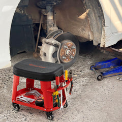 The red garage stool with equipment tray and tool holder shown next to a car wheel and suspension