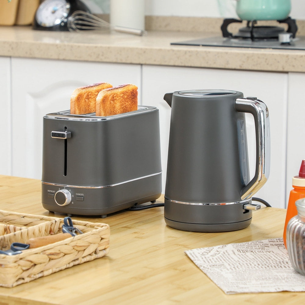 The kettle and toaster set in a kitchen setting with toast in the toaster and water boiling in the kettle