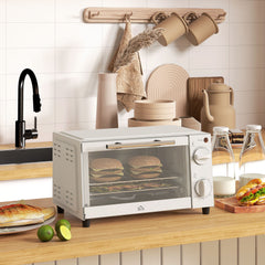 The cream mini oven placed on a wooden kitchen worktop with food cooking inside
