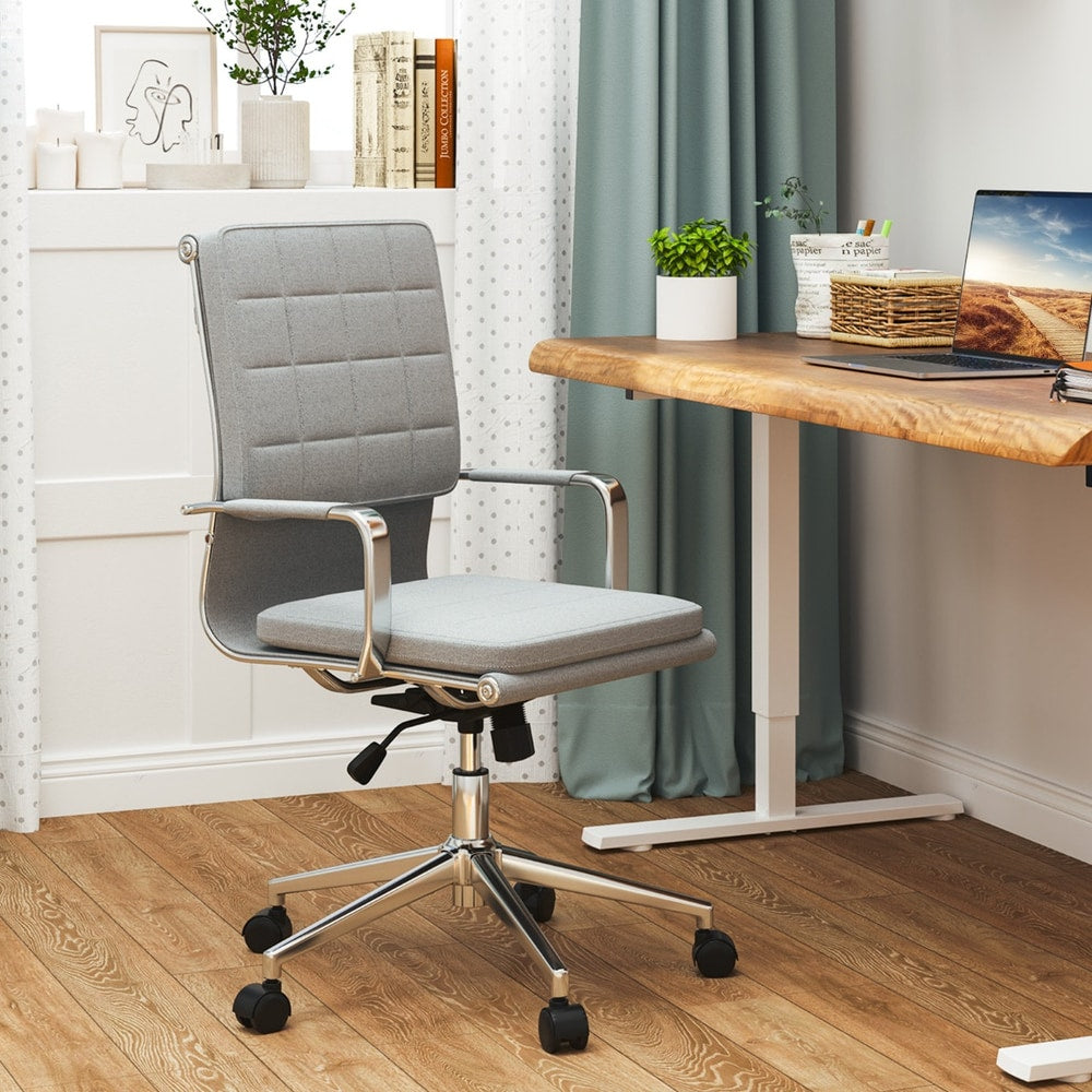 The office chair placed in a home study next to a wooden desk and a window