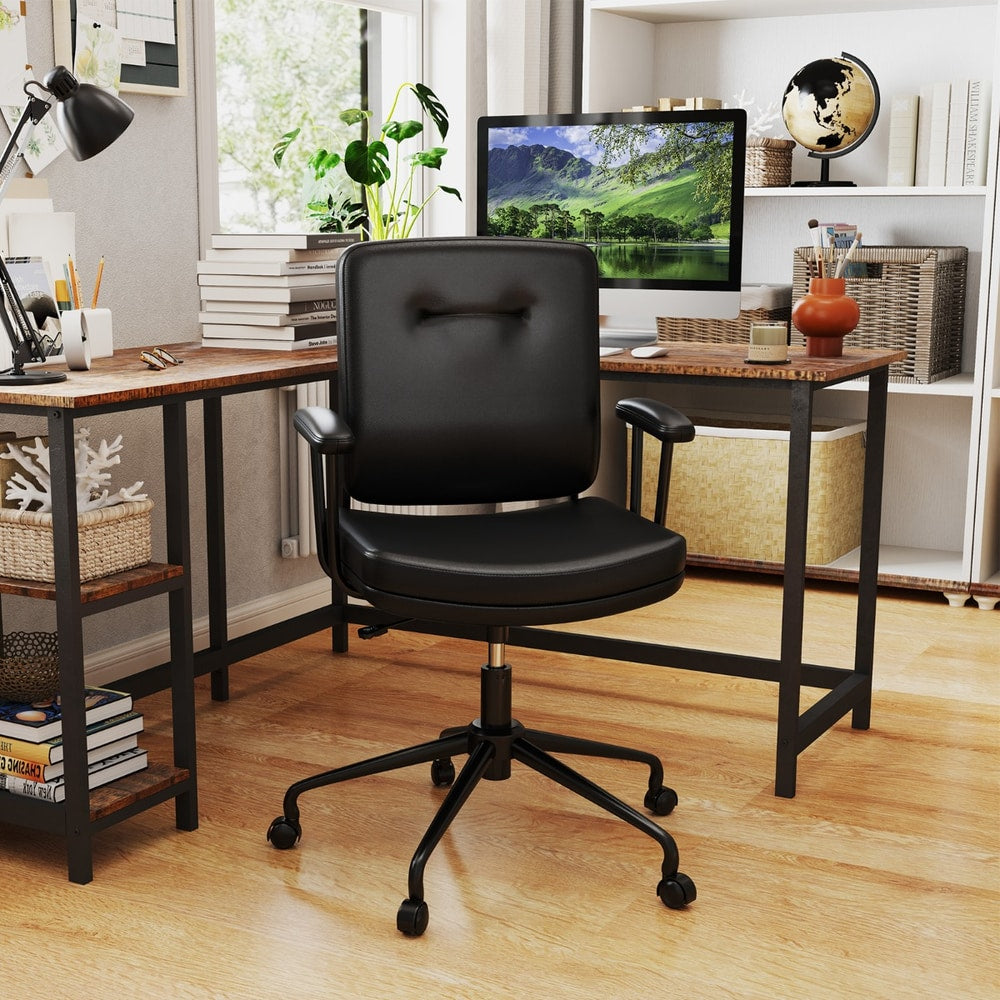 The office chair positioned in a home workspace with a wooden desk and shelves in the background