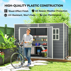 A man with a bicycle stands by the grey garden shed, which is in a garden setting