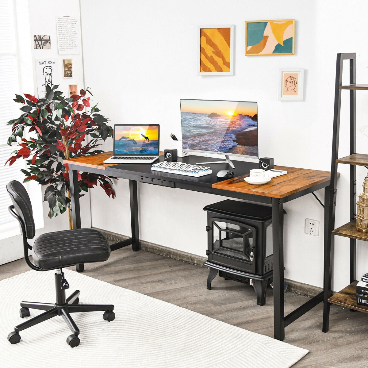 The office desk set up in a home office with a chair, plant and wood burning stove