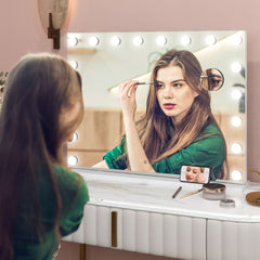 A woman applying makeup using the lighted dressing table mirror