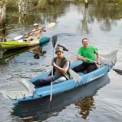 Two people paddling an inflatable canoe boat on a lake