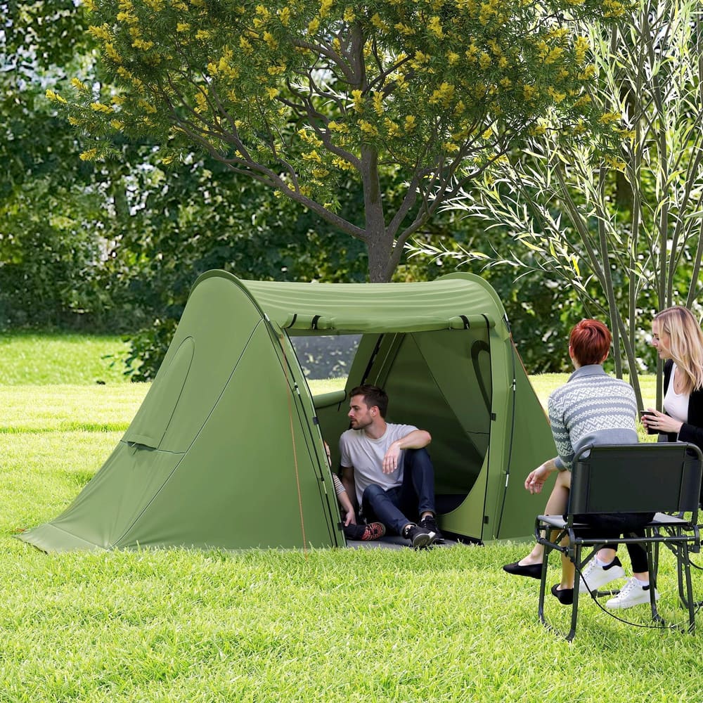 The camping tent set up in a grassy garden with two people sitting outside