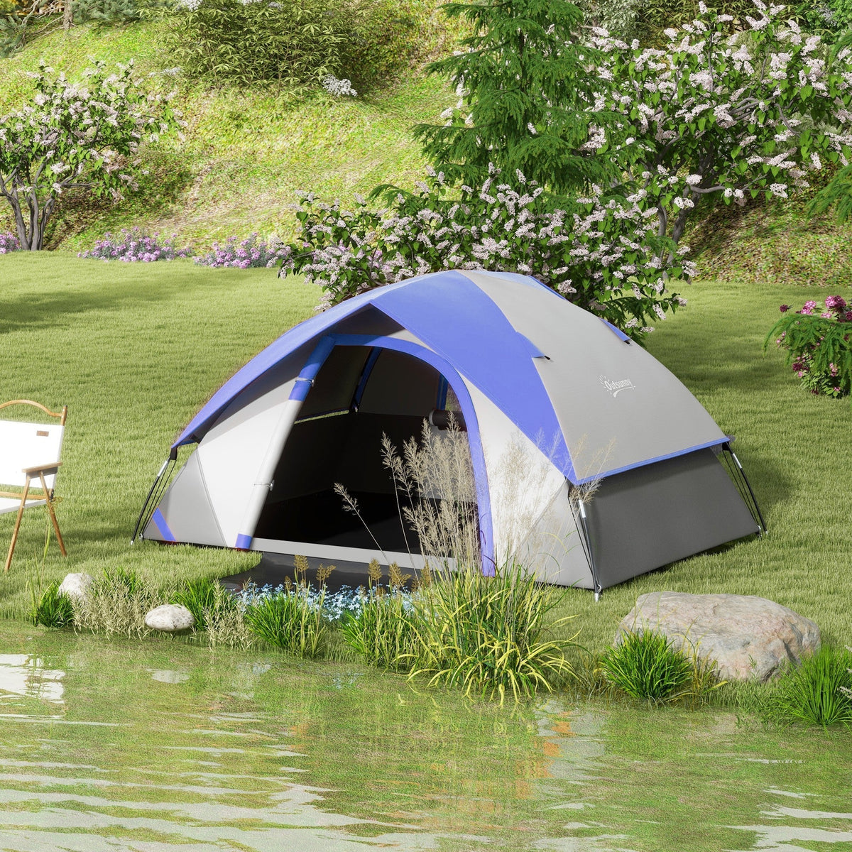 The dome tent set up on a grassy bank beside a lake with a chair nearby