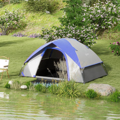 The dome tent set up on a grassy bank beside a lake with a chair nearby