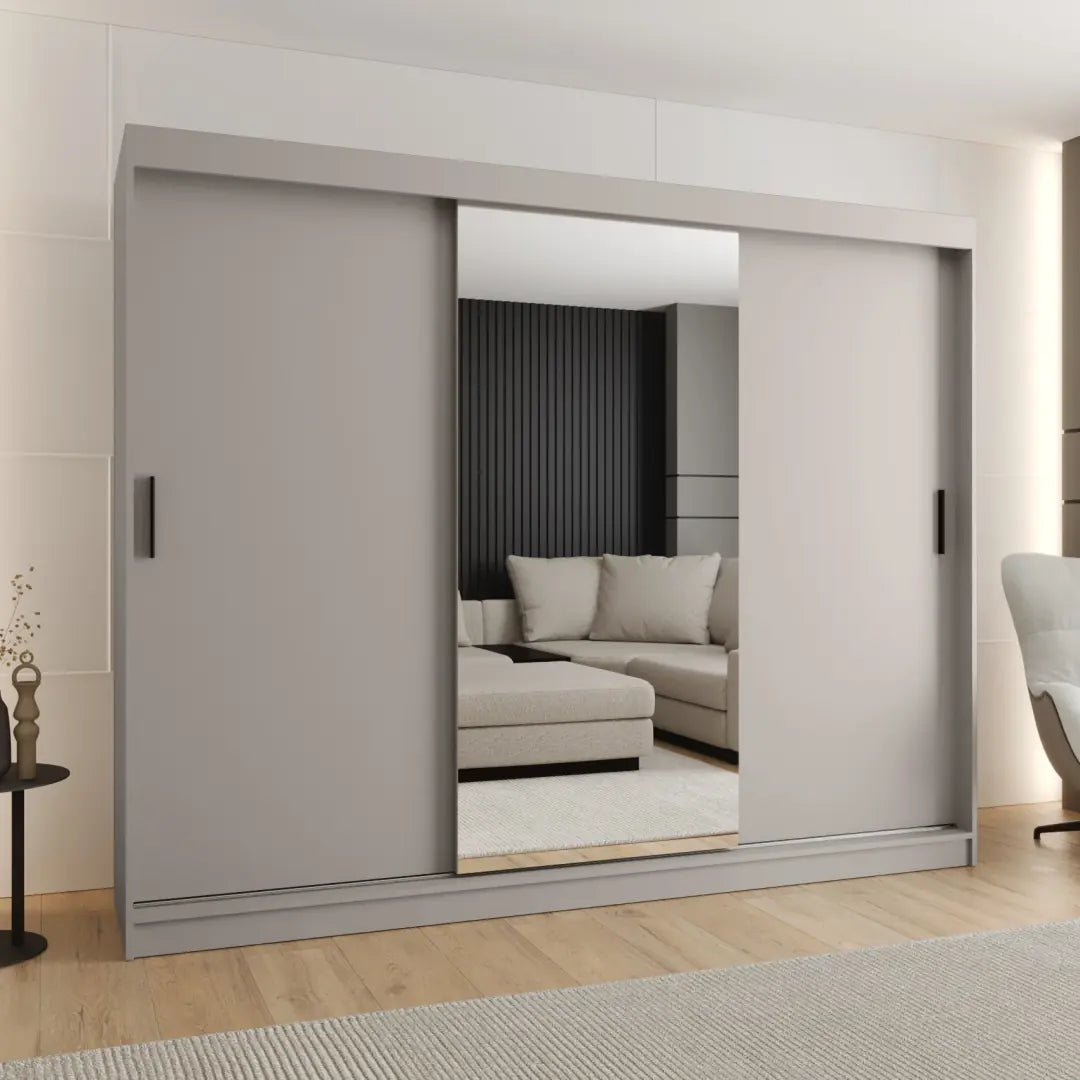 Sliding door wardrobe in a light grey finish with mirrored doors reflecting a sofa