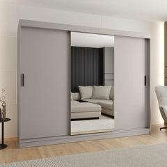 Sliding door wardrobe in a light grey finish with mirrored doors reflecting a sofa