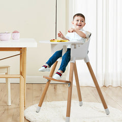 The wooden high chair with a white tray and padded seat standing on a rug
