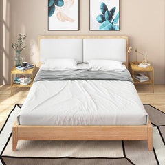 Two natural bamboo bedside tables placed either side of a bed in a bedroom setting