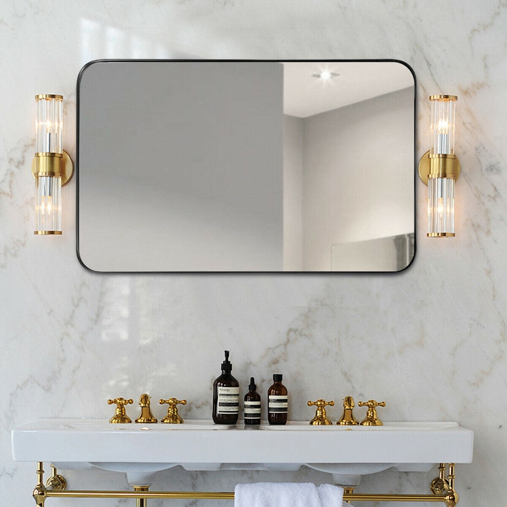 The rounded corner bathroom mirror is displayed above a double sink vanity with wall lights