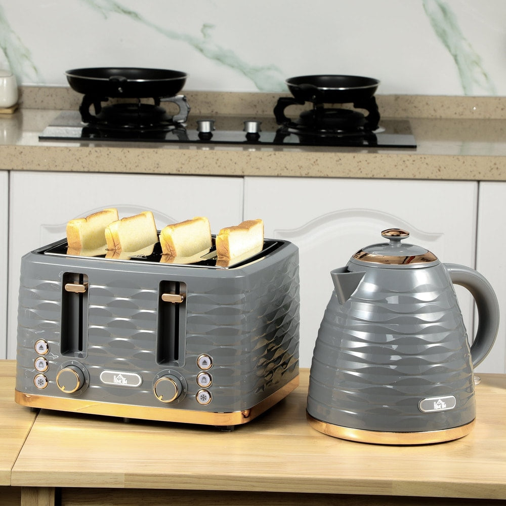 The four-slice toaster with bread slices and a matching kettle on a wooden kitchen worktop