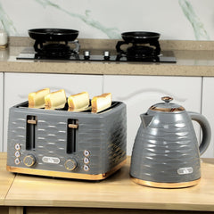 The four-slice toaster with bread slices and a matching kettle on a wooden kitchen worktop