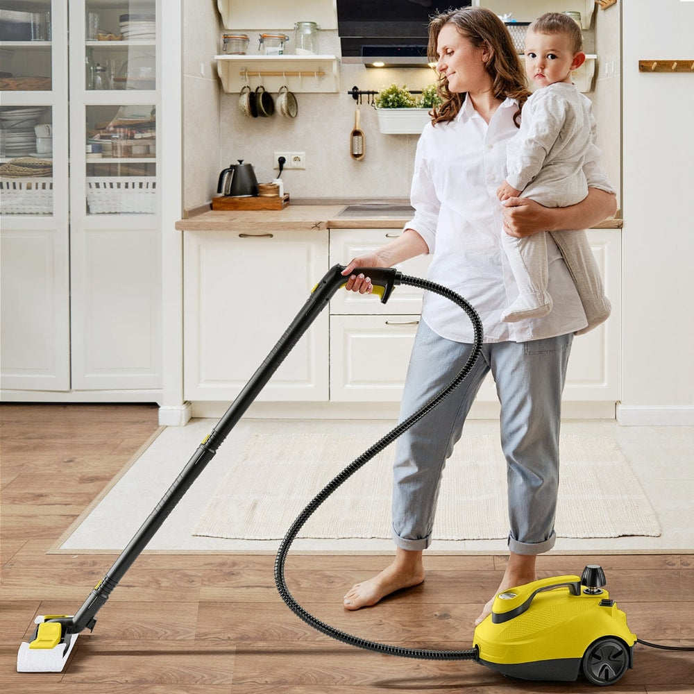 Woman holding a baby while cleaning a kitchen floor with the yellow steam cleaner