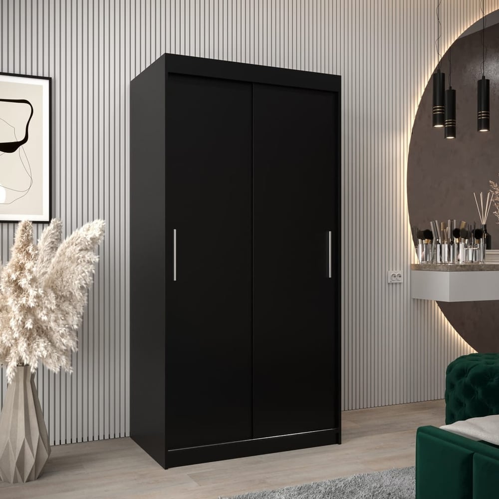 The black sliding door wardrobe has two mirrored doors and stands in a bedroom setting