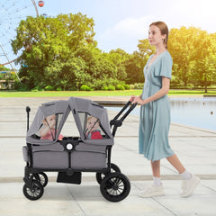 The baby stroller being pushed by a woman with two children under the canopy