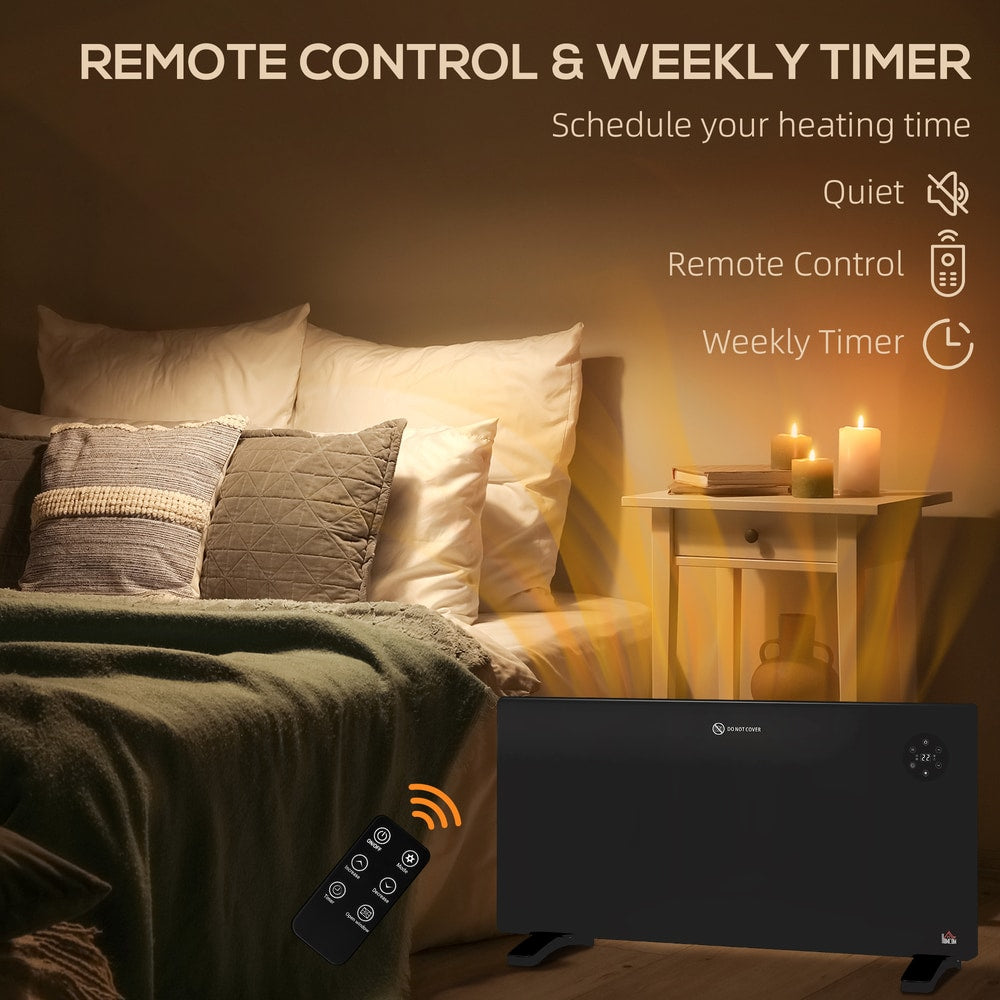 Black electric convector heater and remote control next to a bed, with text about timer