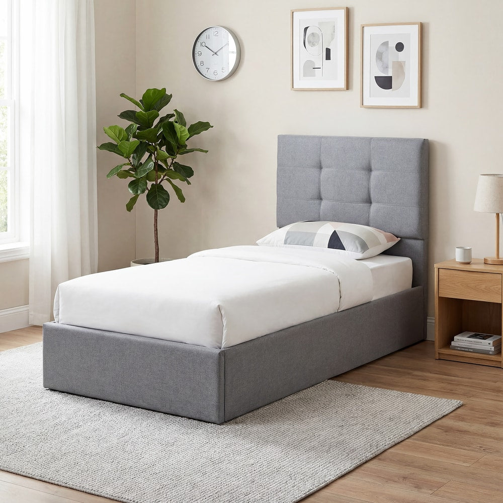 The grey ottoman bed made up with white bedding in a bright, modern bedroom