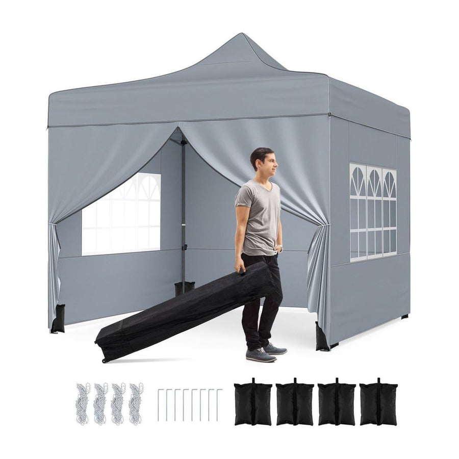 10 x 10 Feet Pop up Canopy Tent with a man carrying the folded frame and accessories laid out below
