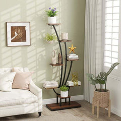 The plant stand placed in a living room next to a sofa with decorative items and plants