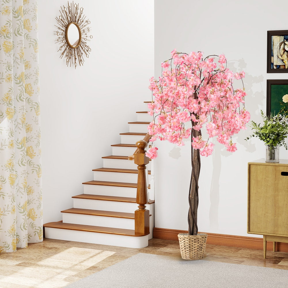 Artificial cherry blossom tree with pink flowers in a wicker pot by a staircase