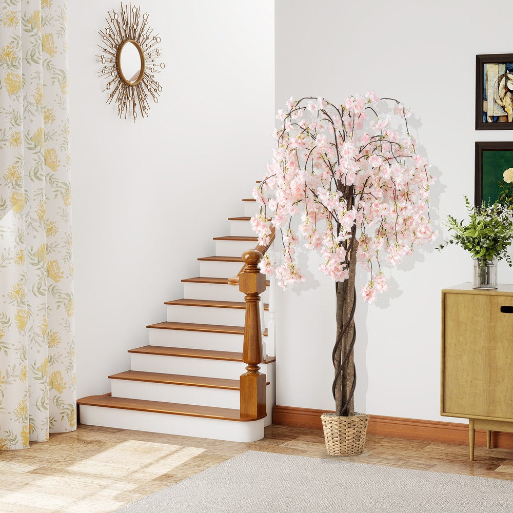 Artificial cherry blossom tree in a woven basket near a staircase