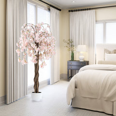 Artificial cherry blossom tree in a white pot in a bedroom setting